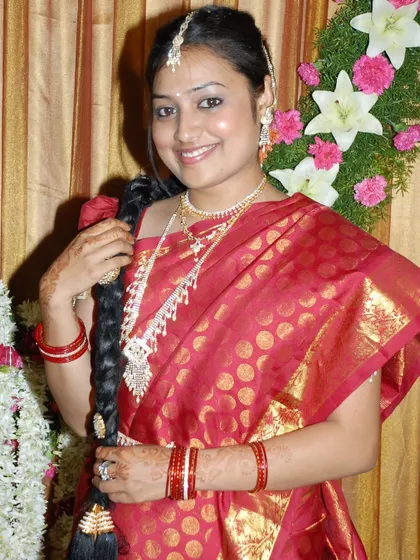 A classic portrait of a woman in a beautiful red and gold saree, a timeless look for any South Indian traditional event. My portrait photography focuses on elegant and flattering poses.