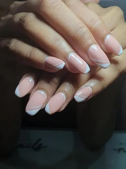 An intricate and modern take on the French manicure. This design uses a pastel base with sharp white lines creating geometric shapes and a heart-shaped tip.