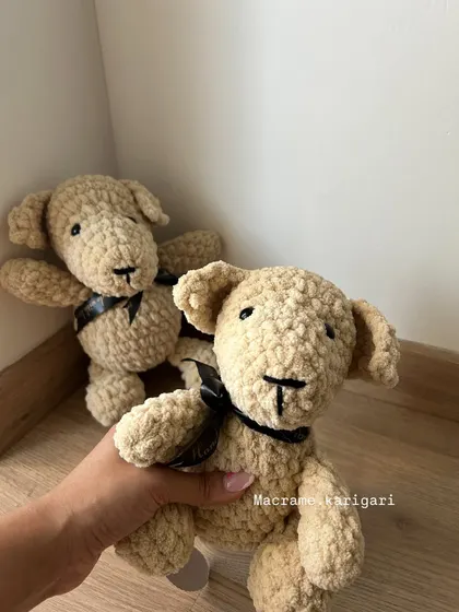 Our take on a classic teddy bear, made with soft, textured yarn. The simple black ribbon adds a touch of elegance. These bears are timeless companions for children and collectors.