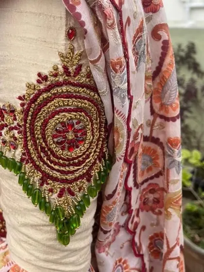 A close-up of the intricate zardozi and beadwork on the sleeve of the lehenga blouse.