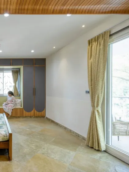 A view of the master bedroom showing the custom wardrobe with curved details and the connection to an outdoor balcony.