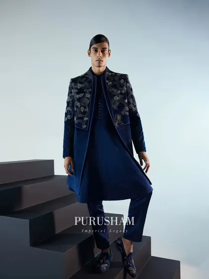 Luxury ensembles setting standards for sophistication. This full-length view of the navy blue velvet bandhgala showcases its elegant drape and the stunning contrast of the silver embroidery.