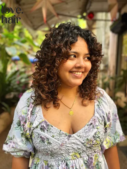 A candid shot of our happy curly client, showing off the movement and bounce of her new haircut.