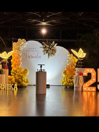 A beautiful and elegant butterfly-themed 25th birthday. The heart-shaped backdrop, warm yellow and white balloons, and glowing butterfly props create a magical and sophisticated ambiance.