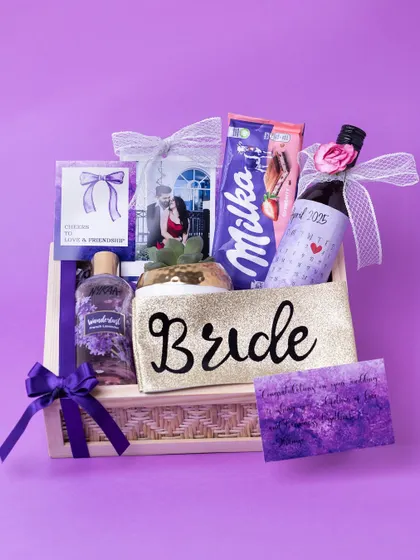 The lavender-themed bride-to-be hamper, showcasing all its contents together in a wooden box, tied with a purple ribbon.