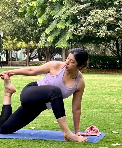 Guiding a student through a challenging pose during a private outdoor session. My focus is on proper alignment and building strength step by step, helping you achieve poses you might not have thought possible.