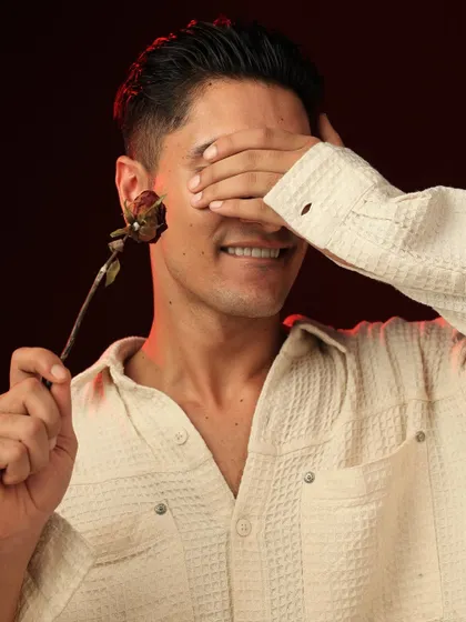 A playful yet mysterious shot, with the model covering his eyes but smiling. This image shows personality and adds a touch of lightheartedness to the series.