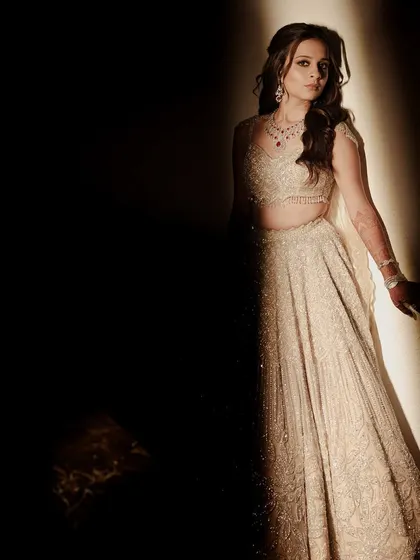 The bride in a moment of quiet elegance. The dramatic lighting creates a beautiful contrast, making her sparkling outfit the star of the show.