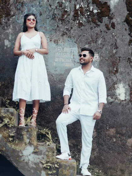 A fashionable pose on moss-covered stairs, with the couple in stylish white outfits, showcasing a blend of nature and urban edge.