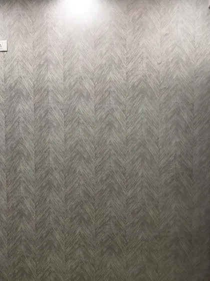 A grey wallpaper with a fabric-like herringbone texture, adding warmth and sophistication.