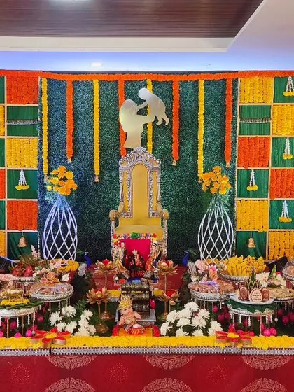 A vibrant baby shower stage with a colorful marigold checkerboard backdrop and a mother-and-child silhouette, creating a modern yet traditional look.