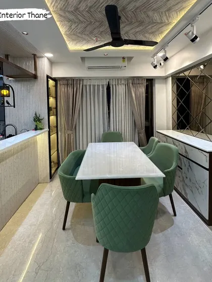 A wider view of the dining and bar area, highlighting the fluted paneling on the counter and the diamond-patterned mirror wall.