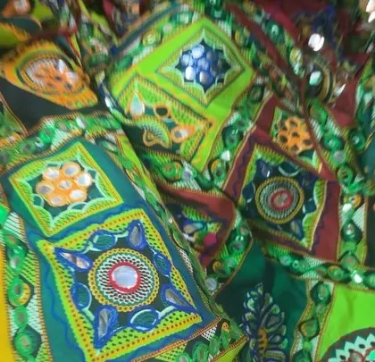 A close-up of the beautiful, mirror-work fabric of a traditional Garba outfit, showing the color and detail we encourage.