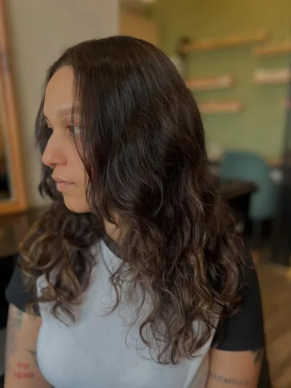A mid-process shot showing the client's natural wavy texture before the final styling. The color is already looking richer and more even.
