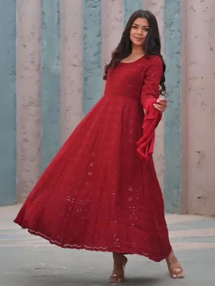 A floor-length red Anarkali suit with delicate embroidery. This is a timeless, elegant design that is perfect for celebrations and can be custom-made to your measurements.