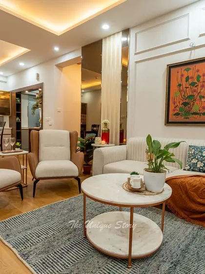 A closer look at the seating arrangement in a neo-classical living room. The combination of a vertically striped sofa, tan and cream accent chairs, and a two-tiered marble coffee table creates a sophisticated yet comfortable conversation area.