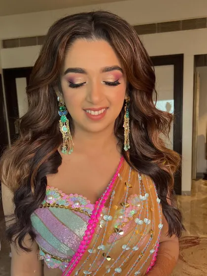 A final look at this beautiful Mehendi glam. The entire look is cohesive, from the colorful outfit to the fresh, glowing makeup and soft, wavy hair.