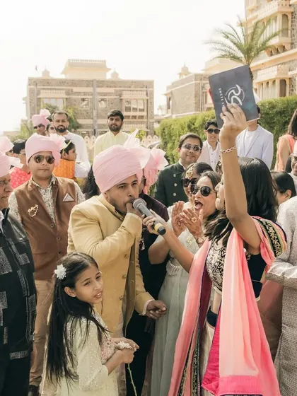 Holding up my cue card but still right in the middle of the action. Even in a chaotic, high-energy baraat, I keep the flow going and the excitement high.
