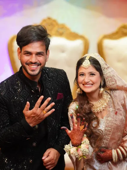 The happy couple showing off their new rings after their engagement. This is a classic shot that celebrates their official commitment.