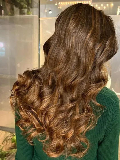 A beautiful example of a soft cinnamon brown balayage. The color is rich and warm, and the curls add so much volume and movement.