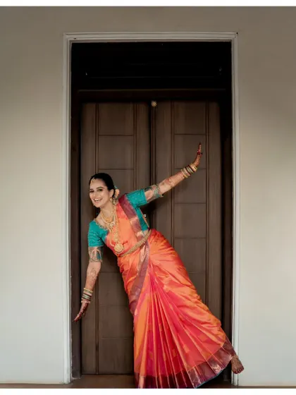 A playful and candid moment from a baby shower shoot. The expecting mother's joyful pose shows that even in traditional attire, we can capture your unique personality and happiness.