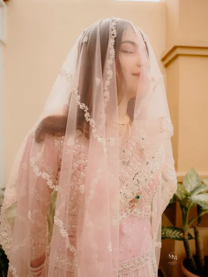A soft and delicate portrait of the bride under her veil. The focus on her serene expression captures the inner peace and joy of her Nikah day.