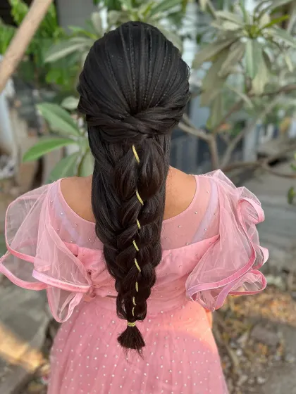 A detailed look at an advanced mermaid braid hairstyle. The intricate weaving and crimped texture create a stunning and unique look for a reception or special event.