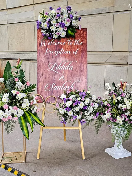 Another view of the elegant welcome sign for Likhila and Santosh, showcasing the beautiful floral arrangements that frame it.