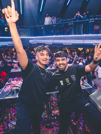Sharing a moment of triumph with a fellow DJ after a successful set. The camaraderie and shared passion are a huge part of the nightlife industry.
