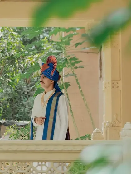 A classic portrait of the groom in his traditional 'pheta' (turban), framed by architectural elements.
