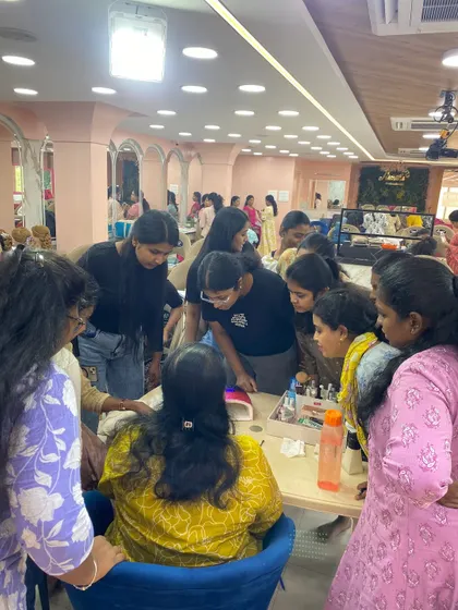 A trainer overseeing a group of students as they practice a new nail art technique.