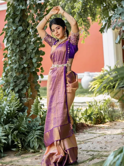 A full-length shot of Megha Shetty in the purple and gold Kanjivaram saree. The traditional drape and the intricate blouse work perfectly together.