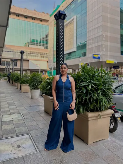 A front-facing view of the denim jumpsuit, showing the clean lines and zipper detail. It's a one-and-done outfit that always looks put-together.