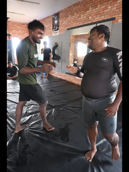 A lighthearted moment between a coach and student during grappling class. We are a family, and we have fun while we train.
