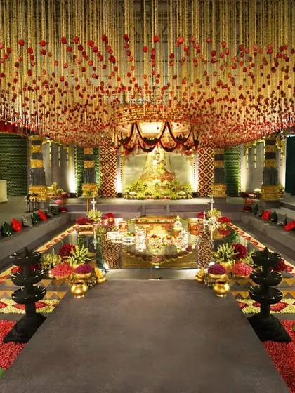 We transformed a hotel ballroom into a breathtaking temple sanctuary. This wide view showcases the grand scale of our design, featuring a central water body, towering custom-built pillars, and a ceiling adorned with thousands of floral strings, creating a truly immersive and sacred space for the wedding ceremony.