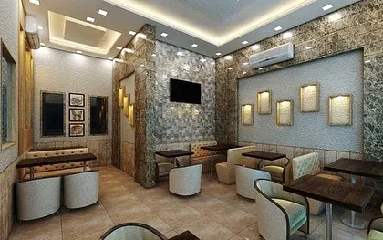 This visualization showcases the lounge area of the cafe, featuring comfortable armchairs and booth seating against a textured stone wall. The design is focused on creating an intimate and relaxing corner within the commercial space.