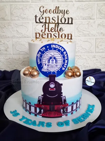 "Goodbye tension, Hello pension!" A special two-tier cake for a retirement from the Indian Railways, featuring the official logo and a train theme to honor 35 years of service.