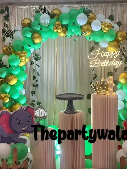 A jungle theme with a green and gold balloon arch and hanging vines for an authentic jungle feel.