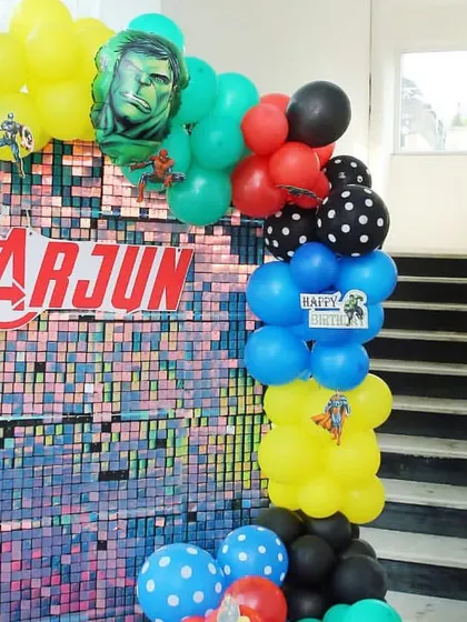 For this Avengers party, I created a shimmering sequin backdrop with the birthday boy's name, Arjun, right in the middle. The Hulk and other hero balloons add to the powerful, fun-filled vibe.