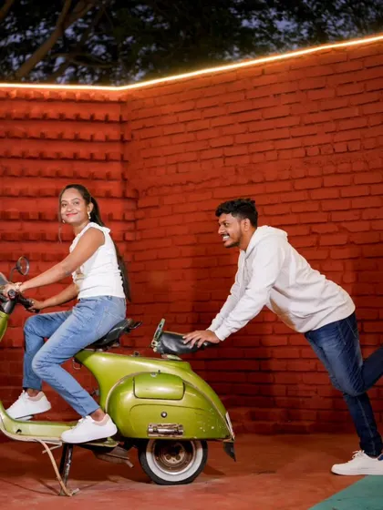 A fun and playful moment with a vintage scooter. These kinds of interactive shots bring out the couple's personality.