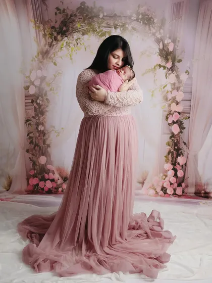 A stunning full-length portrait of a mother in a flowing gown holding her newborn baby, creating a truly elegant and memorable image.