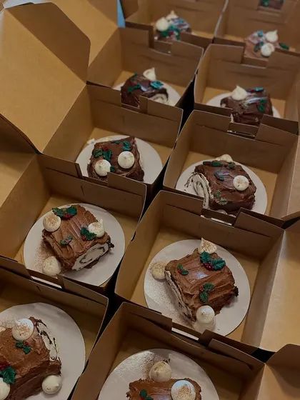 Boxing up individual mini Yule log cakes, perfect for holiday gifts.