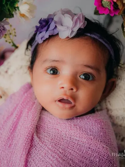 Another beautiful portrait of this little one, framed by a bouquet of flowers. The soft lighting highlights her perfect features.