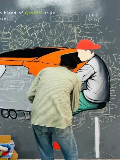 Here you can see the layering process, with a character being painted over a background of graffiti-style chalk sketches. This blend of styles gives the final piece depth and an urban feel.