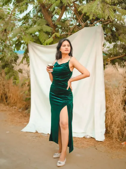Another shot with the green velvet dress, this time holding a glass. It adds a touch of glamour and storytelling to the outdoor shoot.