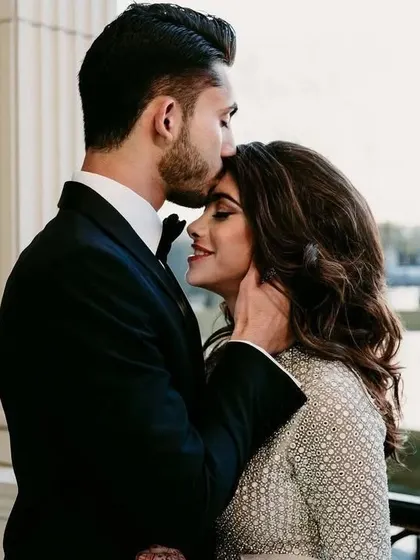 A beautiful, intimate moment. I can design a similar sparkling gown and a classic tuxedo for a timeless and romantic reception look.