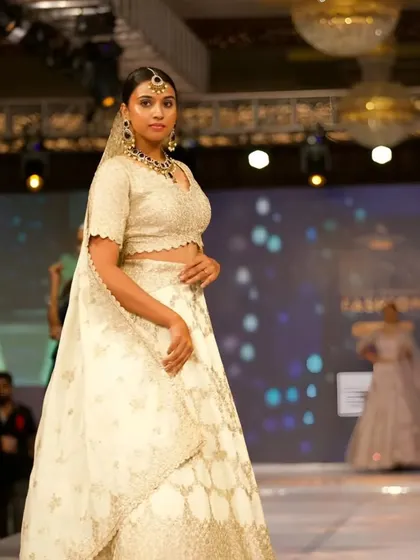 A model on the runway wearing one of my Kundan sets with a beautiful white lehenga. This shows how versatile my pieces are for high-fashion looks.
