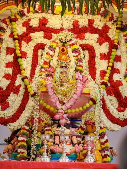 The central deity adorned with a magnificent arrangement of flowers for the Shat Chandi Homa. This powerful ceremony invokes the energy of the Divine Mother in her fierce and protective form.