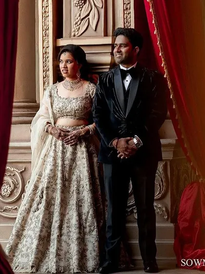 A grand reception portrait set against dramatic red curtains and ornate architecture, capturing the elegance of the evening.