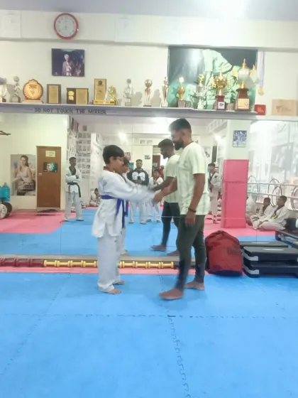 A student receives his blue belt.